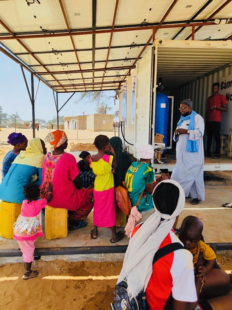 A member of the local community talking to his elder at the Banneexu Ndox water kiosk